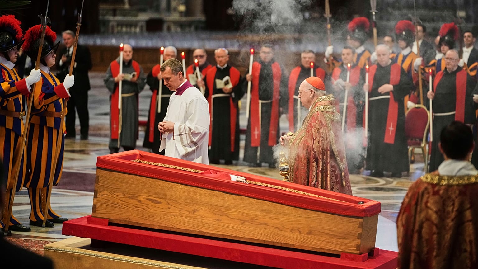 Kardinal Camerlengo Kevin Joseph Farrell, Mitte rechts, verbreitet Weihrauch um den Leichnam von Papst Franziskus im Petersdom im Vatikan, Mittwoch, 23. April 2025