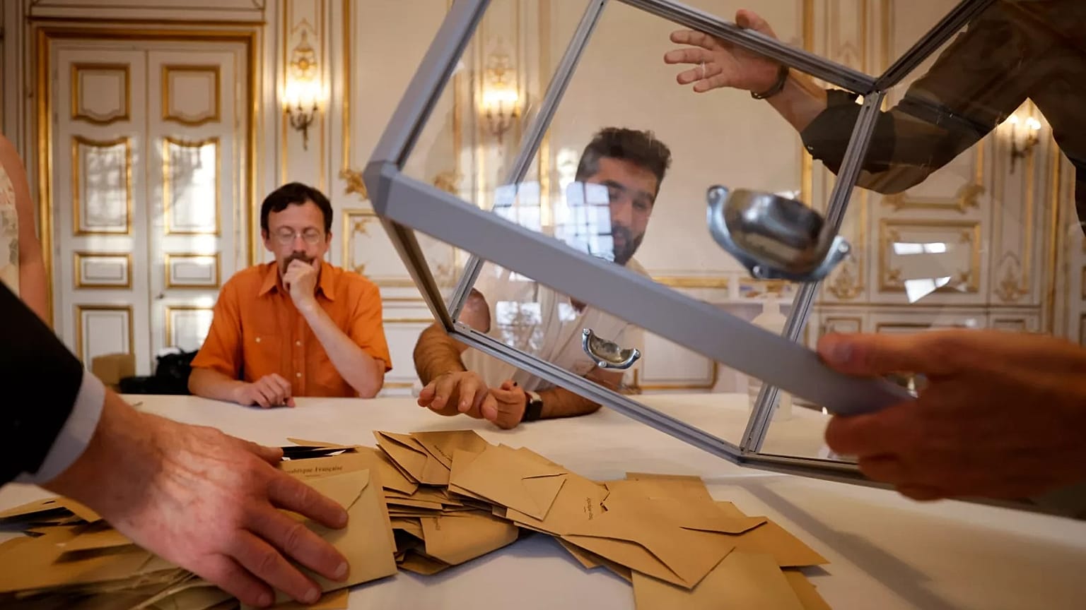 Volunteers empty a ballot box after the first round of the parliamentary election in Strasbourg, 12 June 2022
