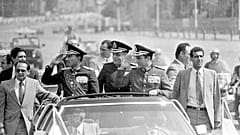 الرئيس المصري أنور السادات, اليسار, يحيي وهو يركب في موكبه إلى موقع العرض العسكري, أكتوبر. 6، 1981 ، في القاهرة