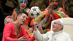El Papa Francisco voltea una pelota de fútbol.