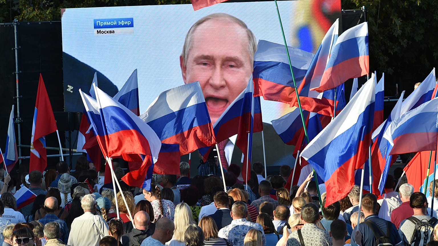 People watch as Russian President Vladimir Putin delivers a speech after signing treaties for four regions of Ukraine to join Russia, 30 September, 2022
