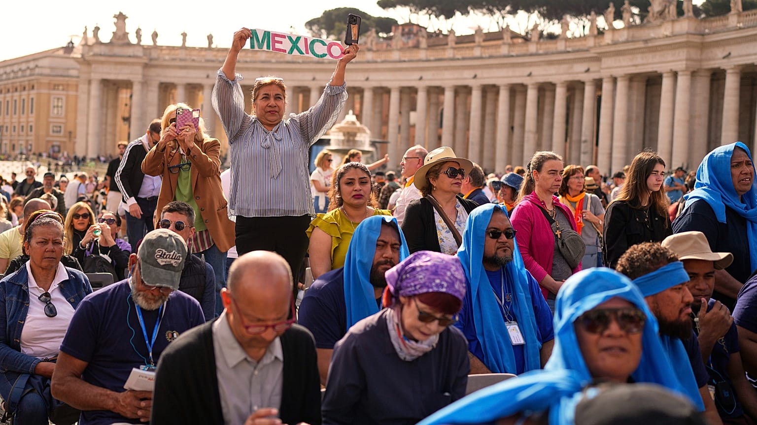 A person holding up the word "Mexico" stands amid the crowd in St Peter's Square at the Vatican, 23 April 2025