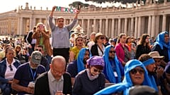A person holding up the word "Mexico" stands amid the crowd in St Peter's Square at the Vatican, 23 April 2025