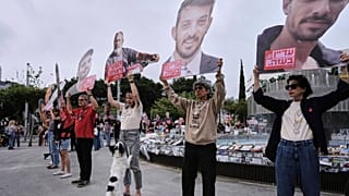 Familiares de los rehenes retenidos en Gaza sostienen sus fotos justo antes de una sirena de dos minutos que marca el Día Anual de la Memoria del Holocausto en Tel Aviv, Israel, el 24 de abril de 2025