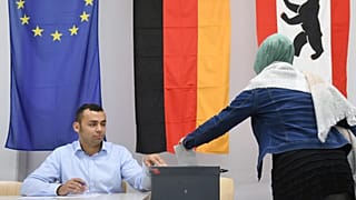 FILE: A woman with a headscarf casts her vote in the German parliament election in Berlin, 24 September 2017