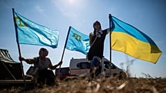 Anwohner halten im Jahr 2015 ukrainische und krimtatarische Flaggen in dem Dorf Chongar in der Ukraine.