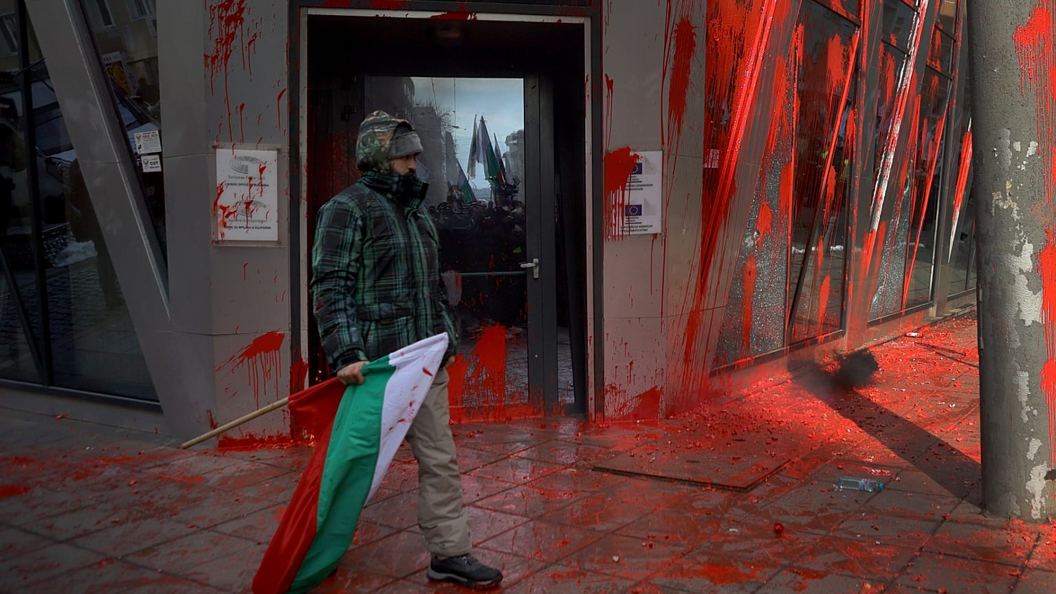 Un manifestant avec le drapeau bulgare marche devant le bureau de la Commission européenne à Sofia lors de manifestations nationalistes, le 22 février 2025.