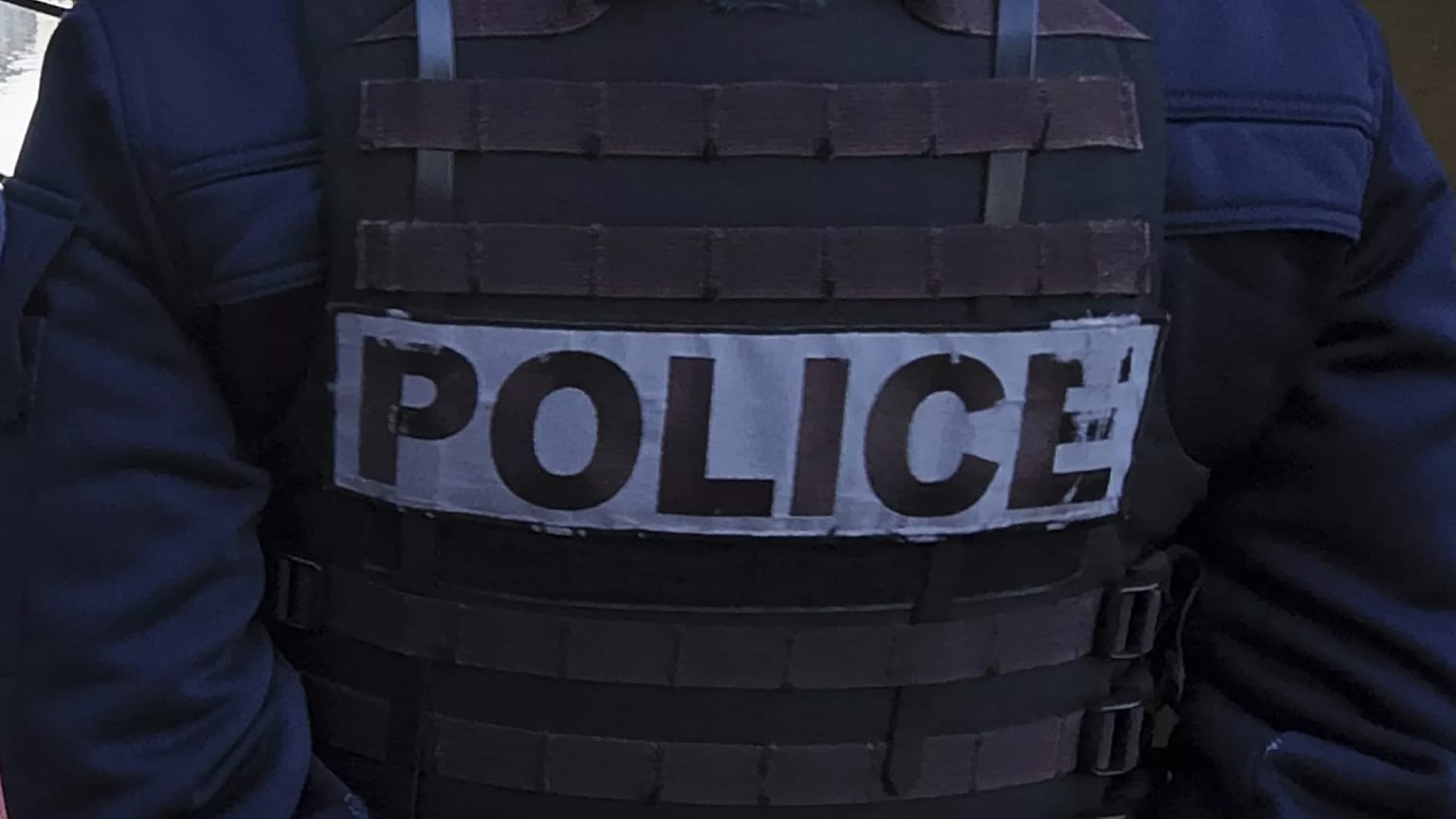 Bir polis memuru, Paris'te Seine Nehri boyunca göçmenleri tahliye eden yetkililerle birlikte çadırların önünde duruyor, 1 Nisan 2025.