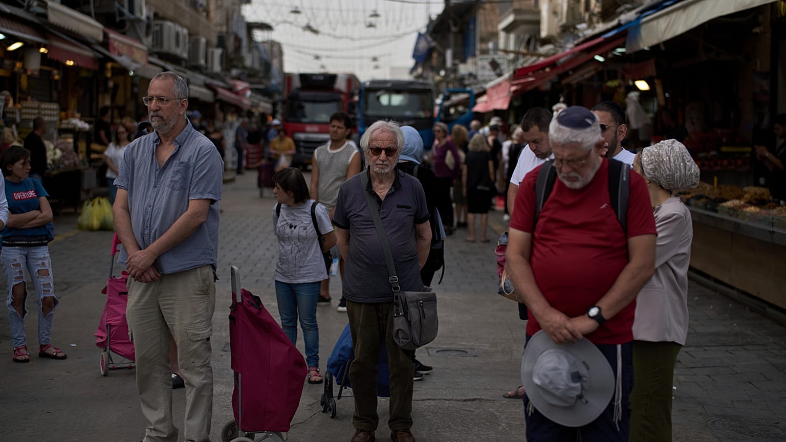 Des Israéliens se figent pendant une sirène de deux minutes au marché Mahane Yehuda, à Jérusalem, en hommage aux victimes de la Shoah, le jeudi 24 avril 2025