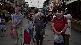 Des Israéliens se figent pendant une sirène de deux minutes au marché Mahane Yehuda, à Jérusalem, en hommage aux victimes de la Shoah, le jeudi 24 avril 2025