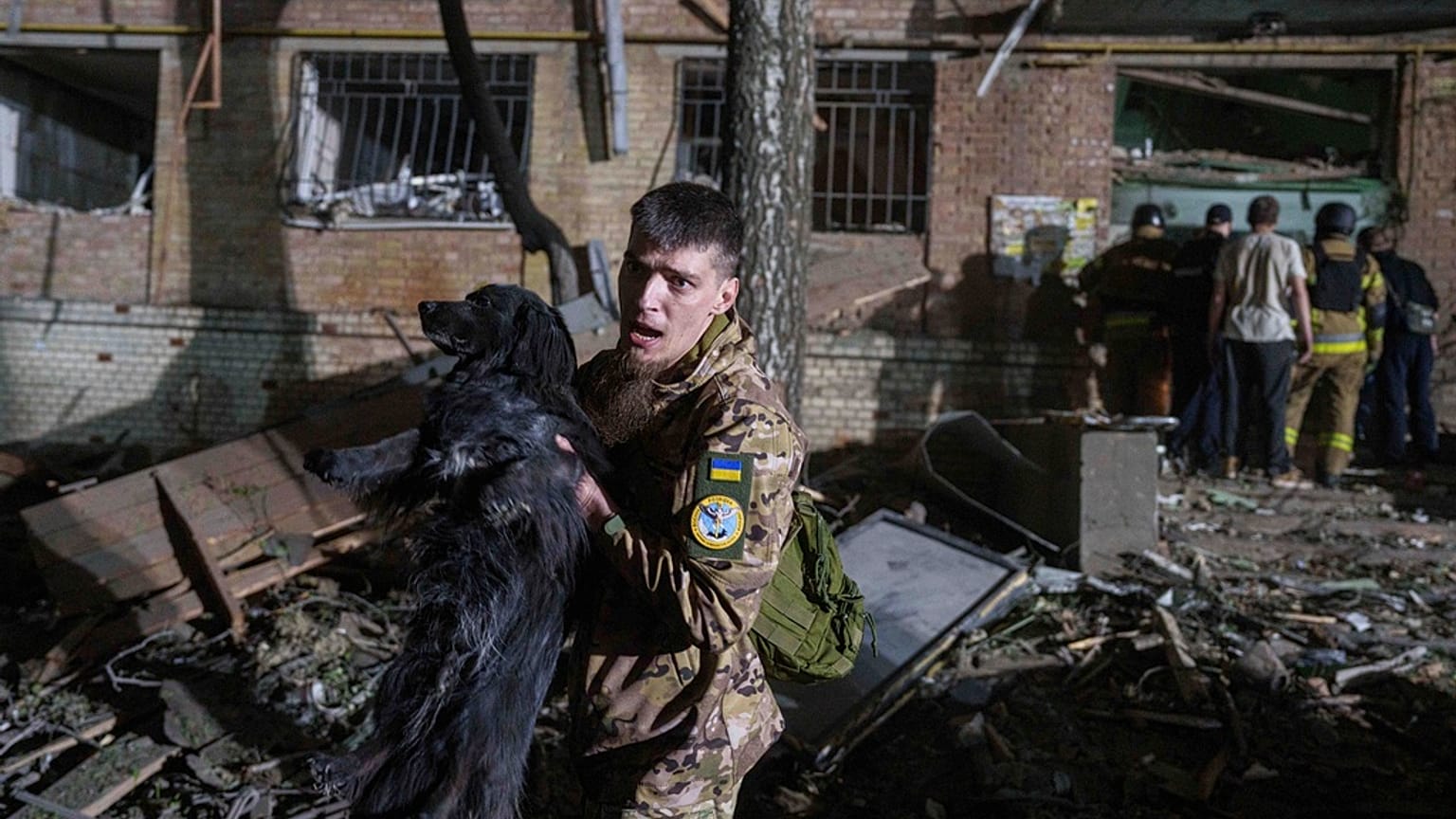Украинский военнослужащий выносит собаку из дома, поврежденного в результате российского авиаудара в жилом районе Киева, Украина, в четверг, 24 апреля 2025 года.