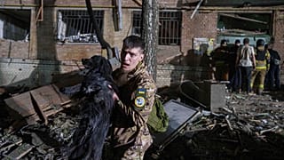 Украинский военнослужащий выносит собаку из дома, поврежденного в результате российского авиаудара в жилом районе Киева, Украина, в четверг, 24 апреля 2025 года.
