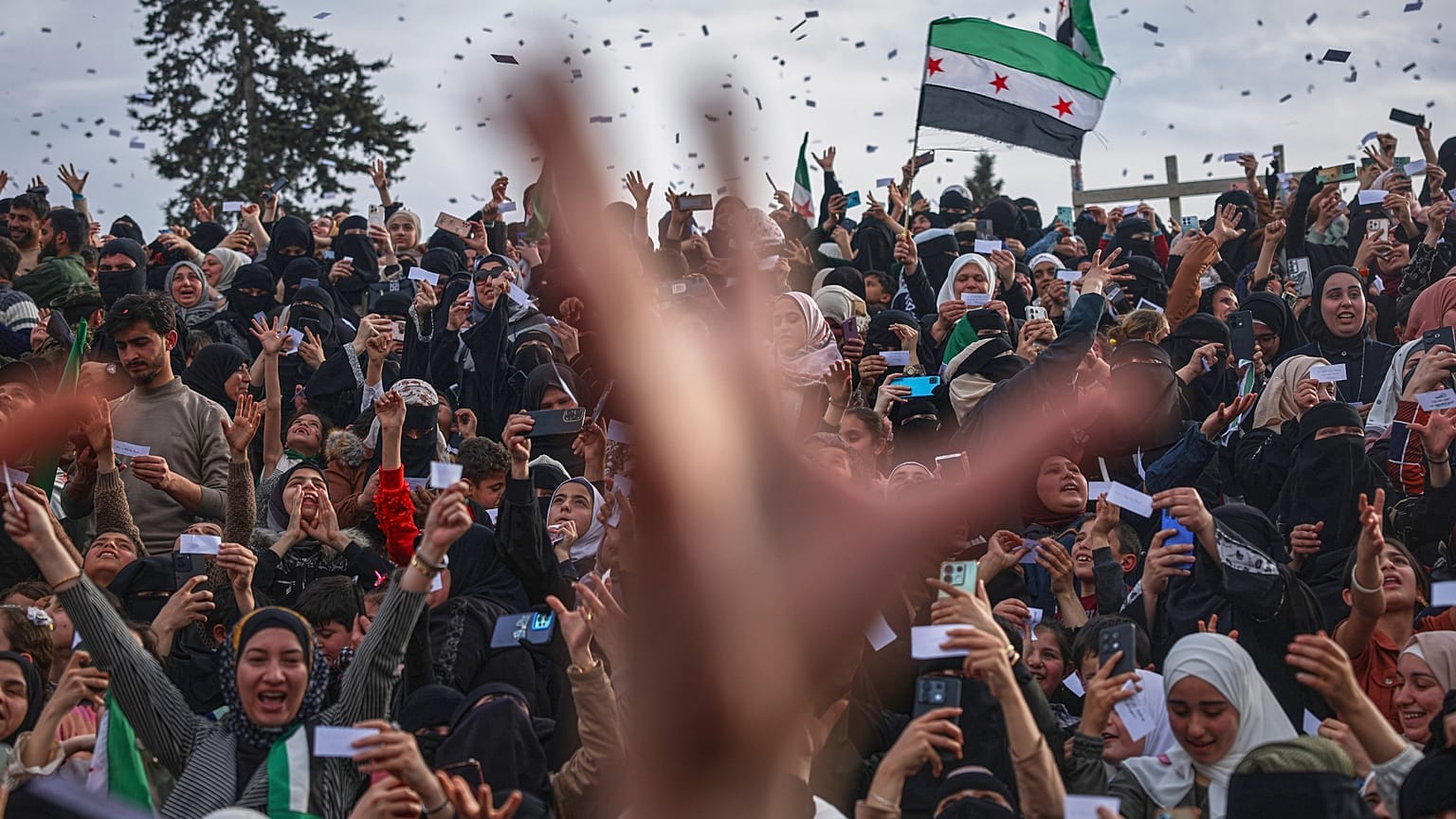 Uma multidão celebra o 10º aniversário da vitória das forças rebeldes sobre o exército de Bashar al-Assad em Idlib, 28 de março de 2025