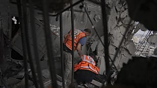 عمال الدفاع المدني في غزة يبحثون بين الأنقاض بعد غارة جوية إسرائيلية استهدفت مبنى سكنيًا في مدينة غزة، الخميس، 24 أبريل/نيسان 2025