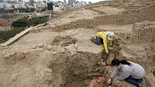 عالمة الآثار غلاديس باز، في الأسفل، ورجل مجهول يعملان في الموقع حيث تم اكتشاف قبر من ثقافة واري القديمة في هرم هوكا بوكلانا في ليما، بيرو، يوم الأربعاء 20 أكتوبر/تشرين الأول 2