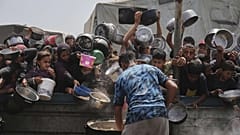 أطفال فلسطينيون يحصلون على الطعام في مركز توزيع في خان يونس، 21 أبريل/نيسان 2025