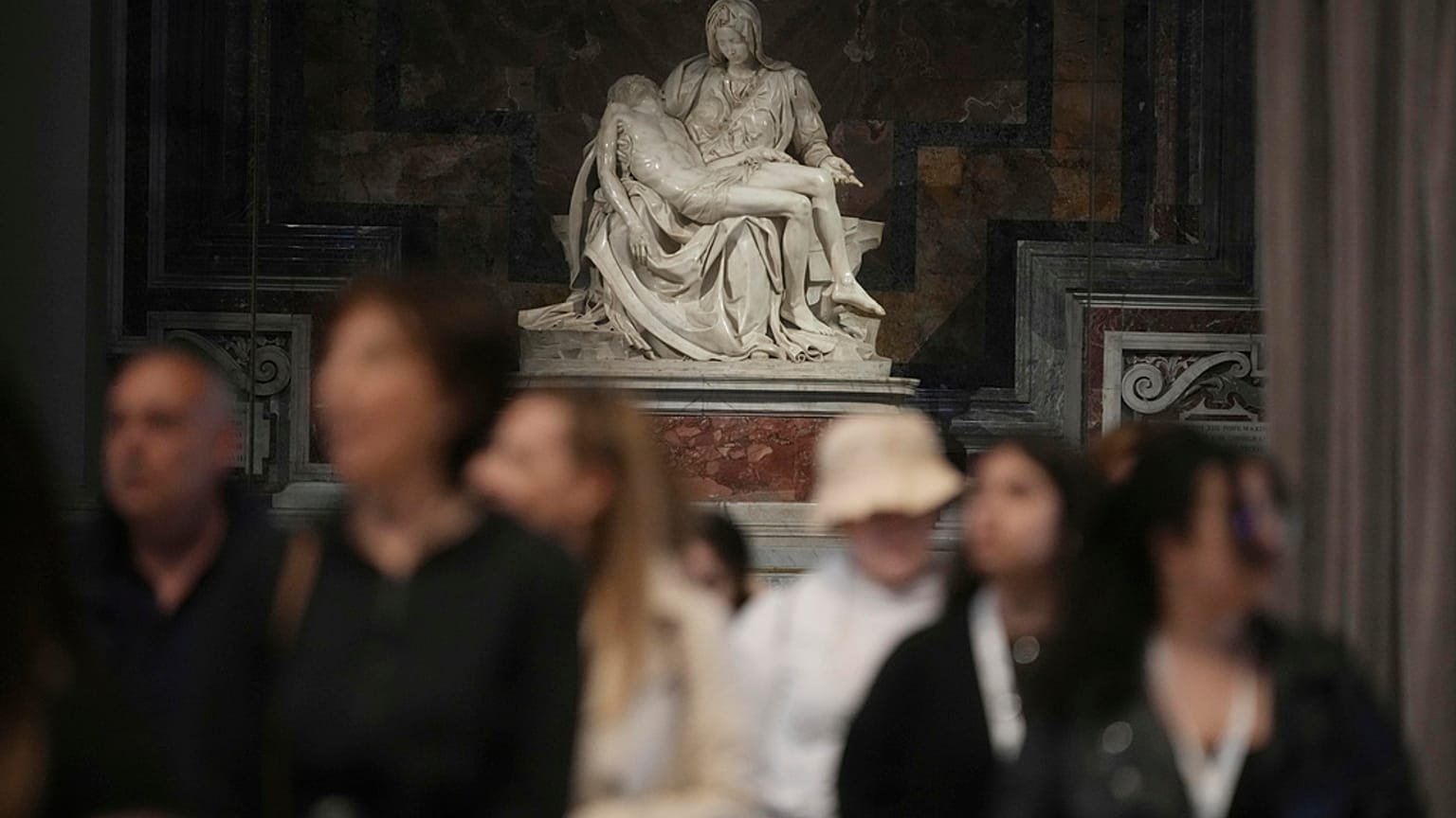 Πιστοί περνούν δίπλα από το μαρμάρινο γλυπτό Pieta' (Οίκτος) του Μιχαήλ Άγγελου καθώς αποτίουν φόρο τιμής στον Πάπα Φραγκίσκο στη Βασιλική του Αγίου Πέτρου, στο Βατικανό