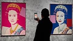 Ein Mann fotografiert einen Siebdruck, der Königin Elizabeth II. darstellt, einen aus einer Serie von sechzehn Drucken von vier Königinnen mit dem Titel Reigning Queens, 1985, von Andy Warhol
