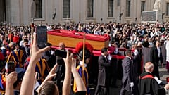 La ceremonia con el cuerpo del Papa Francisco, que yacerá en estado en la Basílica de San Pedro durante tres días, pasa entre la multitud en el Vaticano, el miércoles 23 de abril de 2025. (AP P