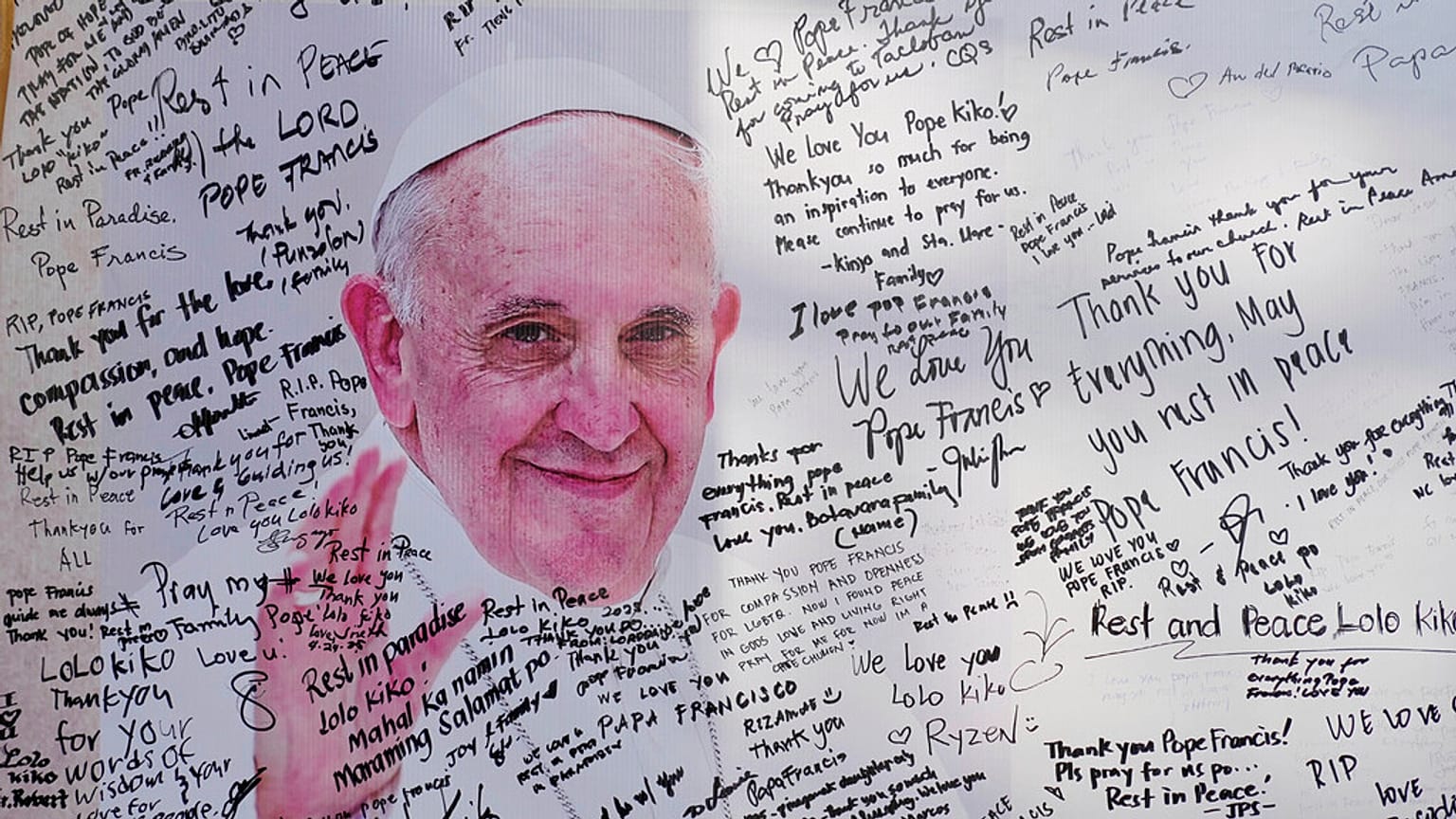 Um quadro de mensagens para o falecido Papa Francisco está coberto de escritos de devotos católicos à porta da Paróquia de São Pedro na cidade de Quezon, Filipinas, quinta-feira, 24 de abril de 2025. 