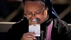 Egy apáca megcsókolja Ferenc pápa fényképét a Szent Péter téri búcsúszertartáson