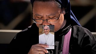 Egy apáca megcsókolja Ferenc pápa fényképét a Szent Péter téri búcsúszertartáson