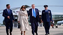 President Donald Trump, escorted by Col. Paul Pawluk, Vice Commander of the 89th Airlift Wing, and first lady Mel
