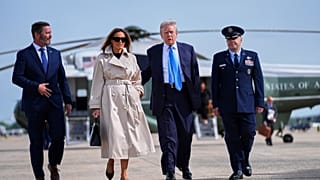 President Donald Trump, escorted by Col. Paul Pawluk, Vice Commander of the 89th Airlift Wing, and first lady Melania Trump, walk to board Air Force One for a trip