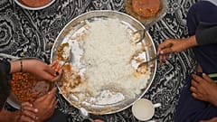 Die Familie Al-Najjar isst Erbsen mit Reis in ihrem Familienzelt in Muwasi, am Rande von Khan Younis im südlichen Gazastreifen, Freitag, 25. April 2025.