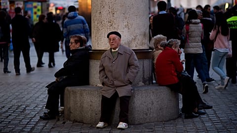 People sit in a public bench in Puerta del Sol square in Madrid, Spain, Thursday, March. 13, 2014. 