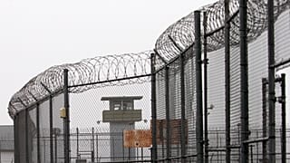 guard tower and barbed wire fencing stand outside Sing Sing, Sunday, Feb. 16, 2020 in Ossining, N.Y.