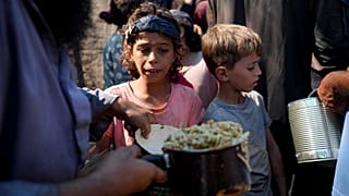 فلسطينيون يصطفون للحصول على توزيع غذائي في دير البلح، قطاع غزة، الخميس، 17 أكتوبر/تشرين الأول 2024.