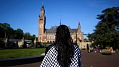 Eine Frau, die eine Keffieh trägt, steht vor dem Internationalen Gerichtshof in Den Haag, Niederlande, Montag, 28. April 2025.