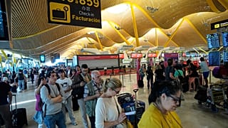 Utasok a madridi repülőtéren a sorban