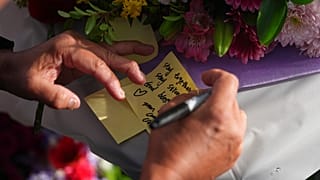 Vincent Meng schreibt eine Notiz bei einer Mahnwache im Kensington Park, nachdem ein Fahrzeug während eines philippinischen Kulturfestivals in Vancouver, British Columbia, in eine Menschenmenge gefahren ist, 27.04.2025