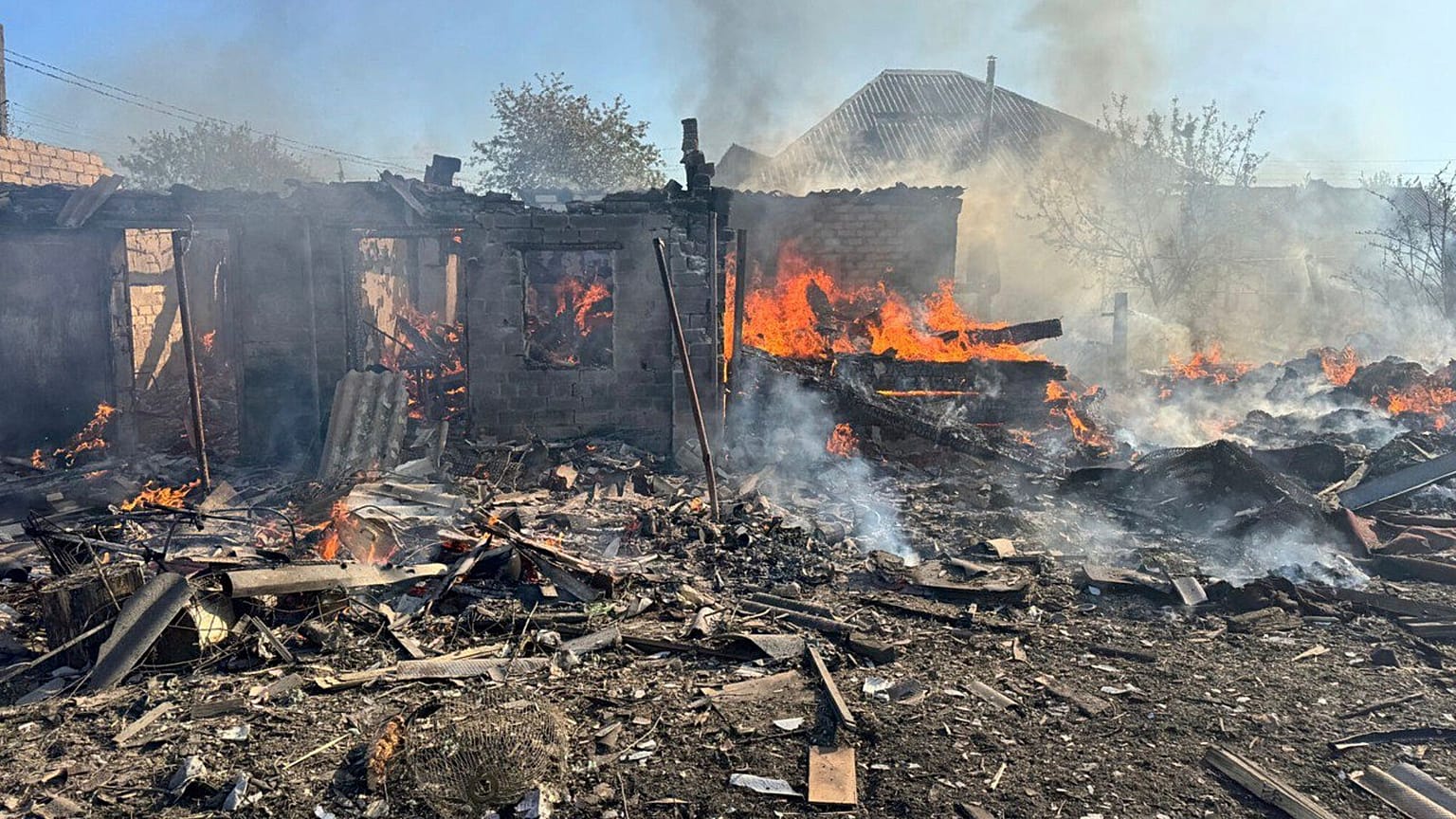 Damaged private houses burn following a Russian air raid in the Donetsk region, 28 April, 2025