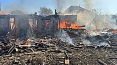Damaged private houses burn following a Russian air raid in the Donetsk region, 28 April, 2025
