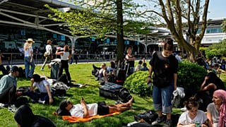 Pasajeros esperan fuera del aeropuerto de Lisboa durante un corte de electricidad a nivel nacional en Lisboa, lunes 28 de abril de 2025.