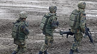 Bundeswehrsoldaten gehen am Montag, 15. Juni 2009, bei einer Leistungsschau des Deutschen Heeres auf dem Truppenuebungsplatz in Munster, Niedersachsen, durch schweres Gelände