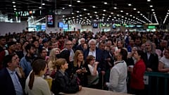 Los pasajeros reaccionan mientras esperan noticias sobre las salidas de trenes, en la estación de Sants en Barcelona, España, el martes 29 de abril de 2025
