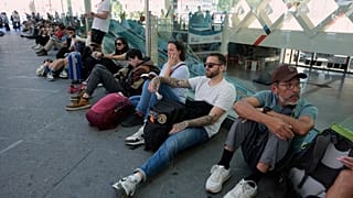 Viajeros esperan en Atocha ante la imposibilidad de subir a un tren debido al apagón. 