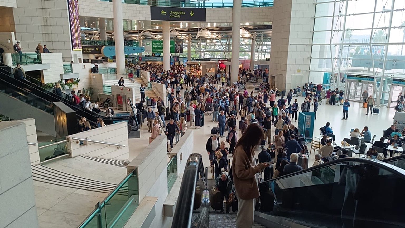 Centenas de passageiros aguardam em filas para obterem informações sobre as bagagens