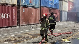 رجال إطقاء في ميناء الشهيد رجائي في بندر عباس الإيرانية بعد وقوع الانفجار