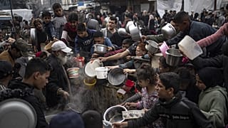 Palestinianos fazem fila para uma refeição em Rafah, 21 de dezembro de 2023