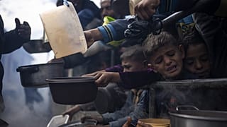 Palestinians line up for a free meal in Rafah, 16 February, 2024