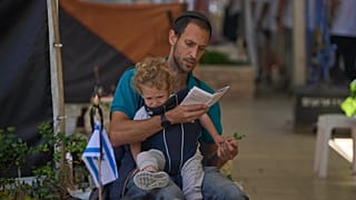 Um homem visita o túmulo de um soldado caído na véspera do dia de homenagem aos soldados mortos do país, no cemitério militar do Monte Herzl em Jerusalém, terça-feira, 29 de abril de 2025
