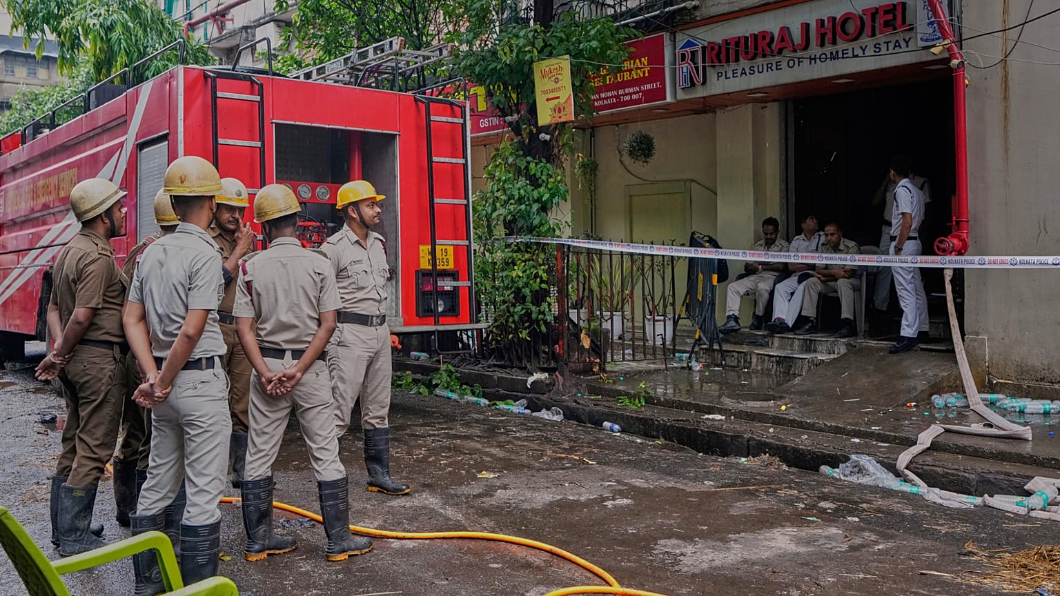 Bombeiros permanecem no local enquanto polícias guardam a entrada de um hotel que pegou fogo na terça-feira, resultando em várias mortes, em Calcutá, Índia, quarta-feira, 30 de abril de 2025