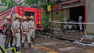 Feuerwehrleute stehen bereit, während Polizisten den Eingang eines Hotelgebäudes bewachen, das am Dienstag in Brand geriet und mehrere Todesopfer forderte, in Kolkata, Indien, Mittwoch, 30. April 2025
