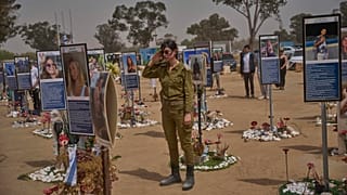 Un soldado israelí saluda mientras la gente guarda dos minutos de silencio al sonar las sirenas antiaéreas que marcan el Día Anual de la Memoria de Israel, cerca del Kibutz Reim, Israel, 30.04.2025