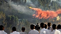 FILE PHOTO - Israelis beobachten von einem Hügel aus, wie sie versuchen, die Brände im Wald unterhalb des Yad Vashem Museums in Jerusalem zu löschen 